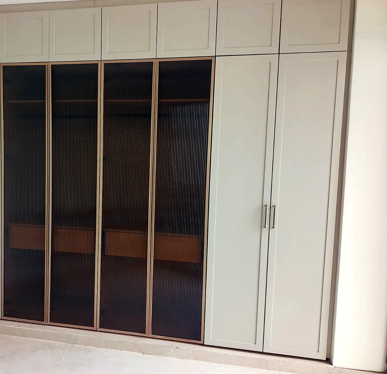 Floor-to-ceiling wardrobe with glass shutters