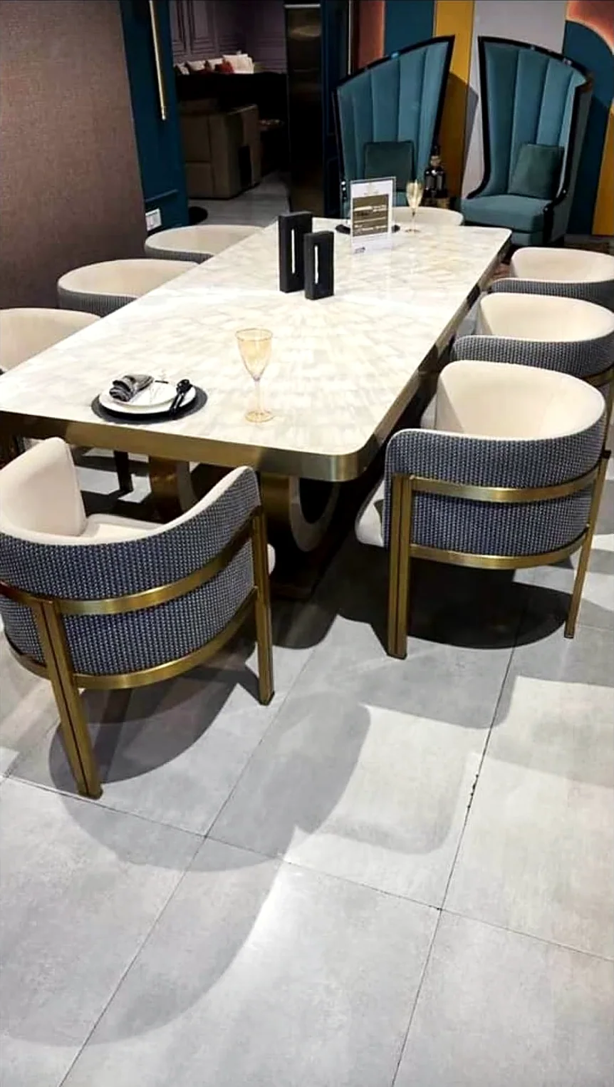 Backlit onyx dining table with brass tub chairs